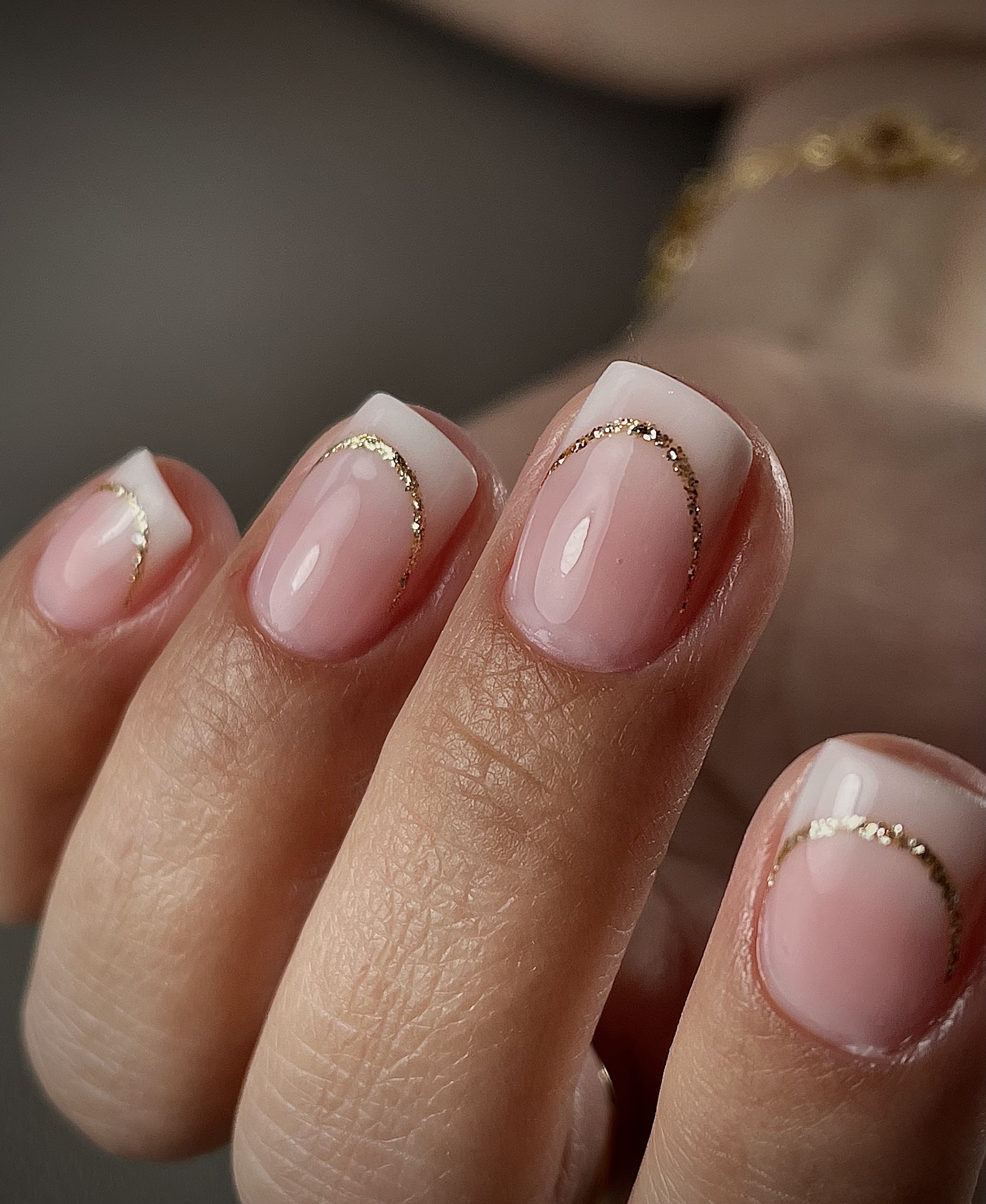Naturel French nagels met gouden glitterbogen, gemaakt bij Beauti & Nails