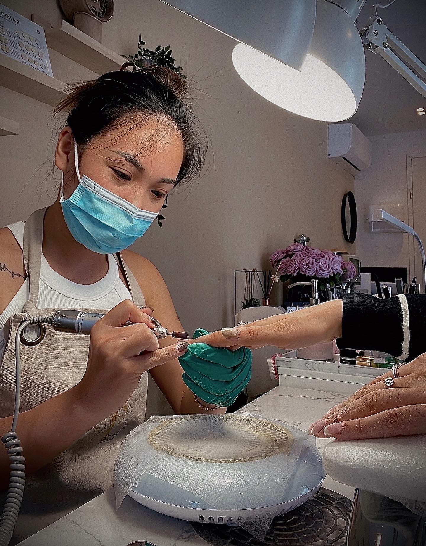 Ti aan het werk in de studio, met mondkapje en nagelfrees